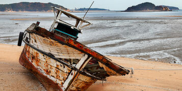 A,Deteriorating,Retired,Fishing,Boat,On,A,Beach,Sand